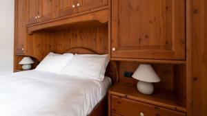 1 dormitorio con 1 cama y armario de madera en Italianway - Coltura 6, en Bormio