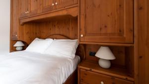 a bedroom with a bed and a wooden cabinet at Italianway - Coltura 6 in Bormio
