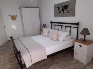 a bedroom with a bed with white sheets and pillows at Alisachni in Kini