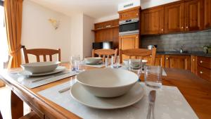 Italianway - Coltura 6 في بورميو: مطبخ مع طاولة عليها صحون وصحون