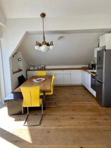 a kitchen with a wooden table and yellow chairs at Haus Gnigl in Salzburg