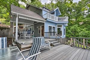 a blue house with a deck with chairs on it at Sunny Providence Cottage Retreat with Dock, Kayaks in Sunrise Beach