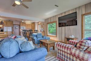 a living room with blue couches and a kitchen at Sunny Providence Cottage Retreat with Dock, Kayaks in Sunrise Beach