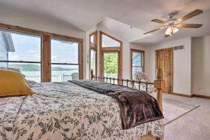 Schlafzimmer mit einem Bett, einem Deckenventilator und Fenstern in der Unterkunft Sunny Providence Cottage Retreat with Dock, Kayaks in Sunrise Beach