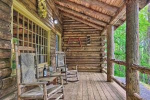 a porch of a log cabin with chairs and a table at Secluded Cabin with Porch on 39 Acres Ski and Hike in Swiss