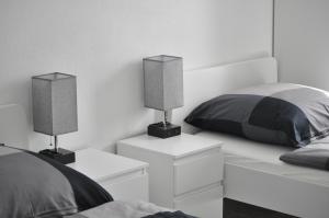 a bedroom with two beds and two lamps on night stands at B Home SLEEP & WORK in Burgrieden