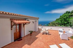 a patio with a table and chairs and the ocean at Casa Serena with sea view in Conca dei Marini