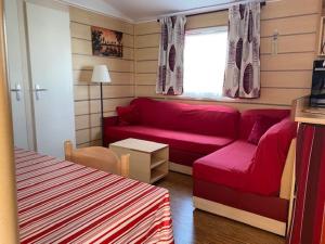 salon z czerwoną kanapą i oknem w obiekcie Mobil Home Valras Plage w mieście Valras-Plage