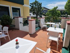 a patio with white tables and chairs on a balcony at Landgasthof zur Goldenen Traube in Podersdorf am See