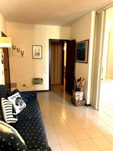 salon z czarną kanapą i podłogą wyłożoną kafelkami w obiekcie Punta Ala Flat w mieście Punta Ala