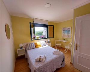 um quarto com uma cama com paredes amarelas e uma janela em Sleeping Sarria em Sarria
