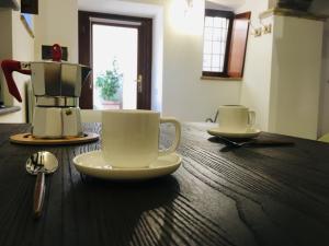 トレヴィニャーノ・ロマーノにあるTrevignano Vecchio - Suite Apartmentの木製テーブルに座ったコーヒーカップ2杯