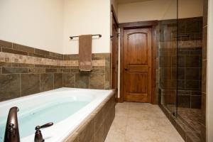 a bathroom with a tub and a wooden door at Crimson Cliffs Unit 5 in Durango +14 photos