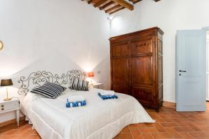 a bedroom with a large white bed and a wooden cabinet at Medieval Charm - Vicopisano Cozy Apartment in Vicopisano