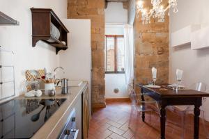 a kitchen with a table and a dining room at Medieval Charm - Vicopisano Cozy Apartment in Vicopisano