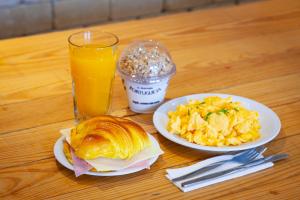a table with two plates of food and a glass of orange juice at RM The Experience - Small Portuguese Hotels in Setúbal