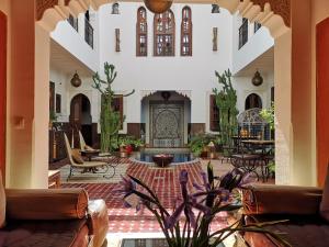 Riad Charme d'Orient Adults Only في مراكش: غرفة معيشة مع كنب ومدفأة
