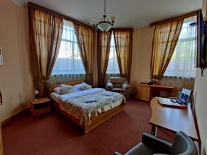 een slaapkamer met een bed, een stoel en ramen bij North Star Hotel in Chimki