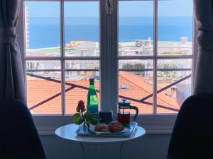 une table avec une assiette de nourriture à côté d'une fenêtre dans l'établissement Apartments Monaco, à Monte-Carlo