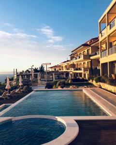 a swimming pool in front of a building at Rigas Boutique Hotel & Spa in Afitos