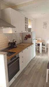 a kitchen with white cabinets and a wooden floor at App Parenzana in Grožnjan