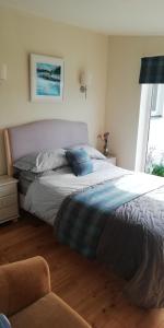 ein großes Bett in einem Schlafzimmer mit Fenster in der Unterkunft Kiloran Self Catering Suite in Skeabost