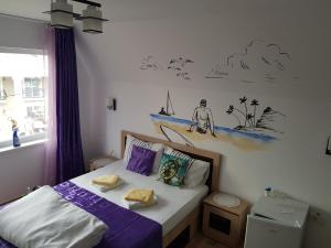 a bedroom with a bed with purple pillows at EL Capitano - Mamaia Nord in Mamaia Sat/Năvodari