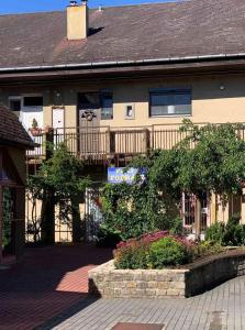 a house with a fence and flowers in front of it at Petra Apartman in Tapolca