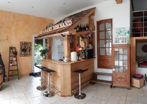 eine Bar in einer Küche mit Hockern in einem Zimmer in der Unterkunft le jardin des quatres saisons in Rilly-la-Montagne