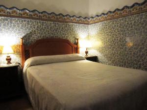- une chambre dotée d'un lit avec du papier peint bleu et blanc dans l'établissement CASA CORRALON, à Grazalema