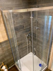 a shower with a glass enclosure in a bathroom at One bedroom house Ragakrasts in Mērsrags