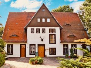 Casa blanca grande con techo marrón en Forsthaus Siehdichum, en Dammendorf
