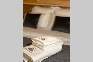uma pilha de toalhas sentadas em cima de uma cama em Chalet L'Élégance - SPA - Serviettes - Peignoirs - Lits faits - Ménage inclus em Rochesson