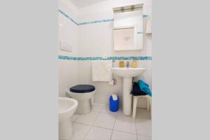 a white bathroom with a toilet and a sink at La Casa blu sul mare - The Blue house by the sea in Castellammare del Golfo +18 photos