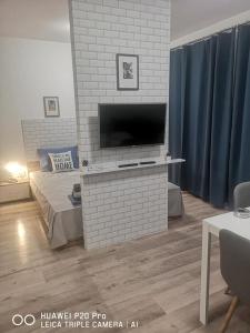 un salon avec une télévision sur un mur en briques dans l'établissement Breezy Studio 5, à Varna