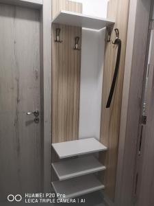 La salle de bains est pourvue d'une porte et d'une étagère blanche. dans l'établissement Breezy Studio 5, à Varna