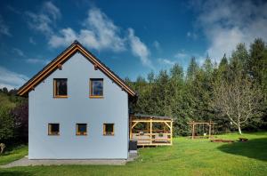 una casa bianca con parco giochi in un campo di Chata pod Jasanem a Dolní Morava