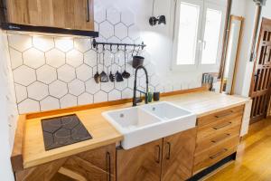 kuchnia z białym zlewem i drewnianymi szafkami w obiekcie Tarifa Cozy House - Tiny House w mieście Tarifa +8 zdjęć