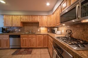 a kitchen with wooden cabinets and a stove top oven at Mears House Unit 2D in Durango +20 photos