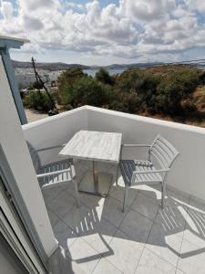 a table and two chairs on a balcony with a table at Venus De Milo in Adamas