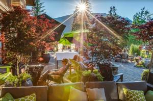 a group of people sitting in chairs in a patio at Beautiful 2 bedroom overlooking Whistler's Green Lake and Mountains! in Whistler