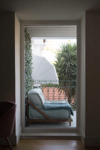 a view of a window with a couch with an umbrella at FLH Príncipe Real Spacious flat with Terrace and View in Lisbon