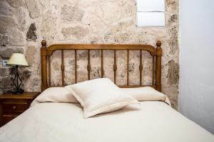 a bed with two pillows on it in a bedroom at Apartamentos Capricho del Valle in Arroyo Frio
