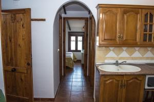 a kitchen with a sink and an arched doorway at Apartamentos Capricho del Valle in Arroyo Frio