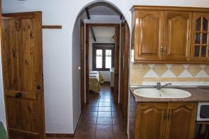 una cucina con lavandino e una porta ad arco di Apartamentos Capricho del Valle ad Arroyo Frio