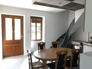 een eetkamer met een houten tafel en stoelen bij Chambres individuelles avec partie commune ou logement entier si disponible Via Rhôna in Vulbens