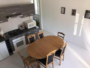 een kleine keuken met een houten tafel en stoelen bij Chambres individuelles avec partie commune ou logement entier si disponible Via Rhôna in Vulbens