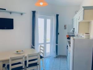 a kitchen with a table and a refrigerator at Pausa mare Ponza - Immobilevante in Ponza +16 photos