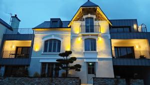 une maison blanche avec un arbre en face dans l'établissement Appart hôtel & Spa La Villa du Port, à Vannes