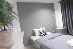a bedroom with a bed with a pillow and a window at Rest Point Sampran in Nakhon Pathom